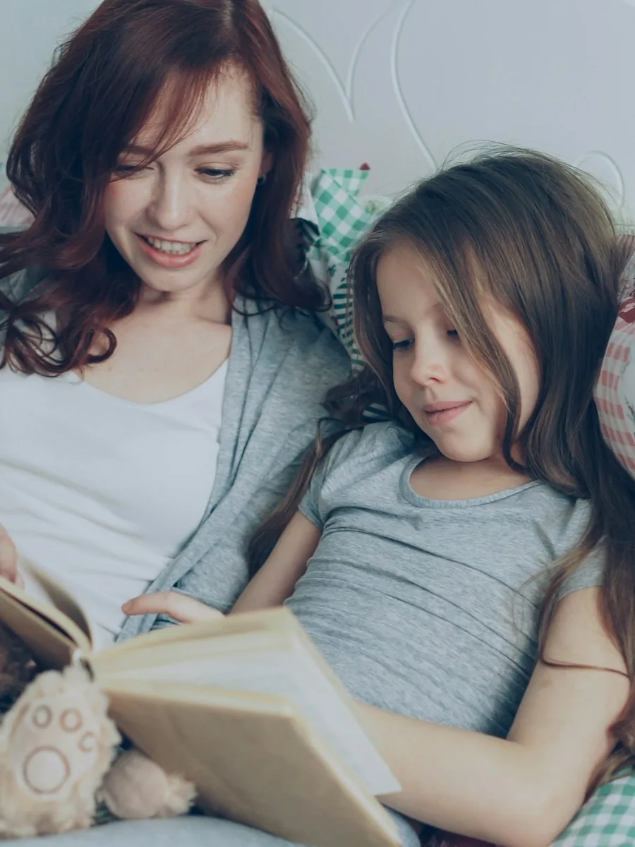 Una madre y su hija leyendo un libro juntas